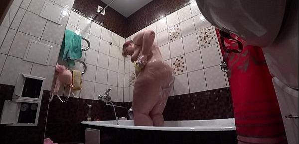  Behind the scenes, a hidden camera is spying on a fat porn model with a big ass in the bathroom.